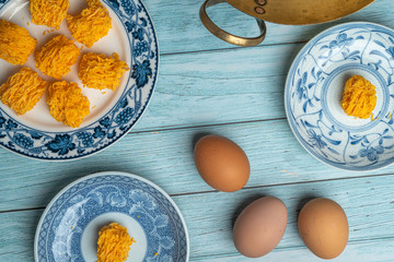 Sweet egg floss on old ceramic dish with blue wooden background - dry sweet egg floss desert Four...