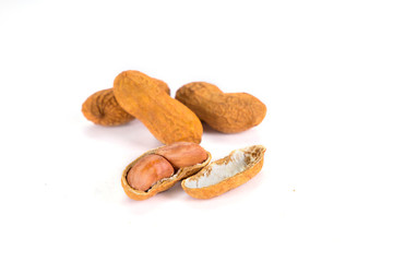 Cracked groundnuts kept on the white background. 
