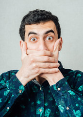 Emotional man keep his mouth closed by his hands