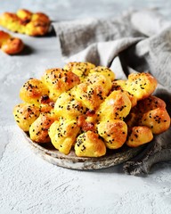 Homemade buns with raisins and sesame seeds on a dark blue wooden background