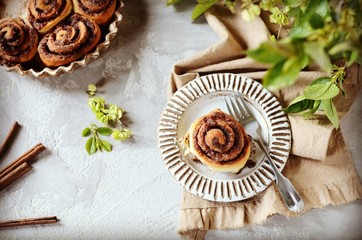 Cinnamon buns in a plate on a gray background, still life