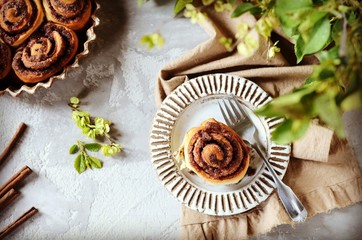 Cinnamon buns in a plate on a gray background, still life