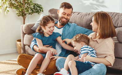 Cheerful parents with kids having fun at home.