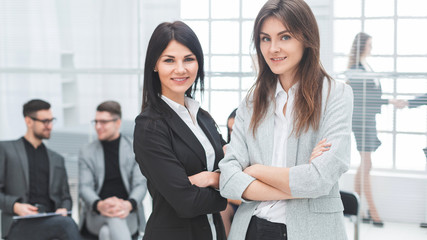two young business woman standing in office