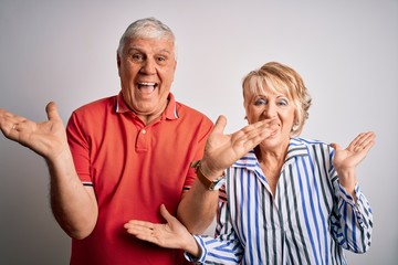 Senior beautiful couple standing together over isolated white background celebrating crazy and amazed for success with arms raised and open eyes screaming excited. Winner concept