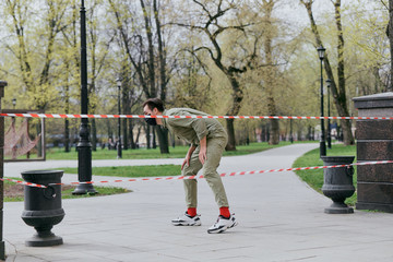 A man climbs over the fence. Violation of the ban on movement in parks and squares. Coronavirus