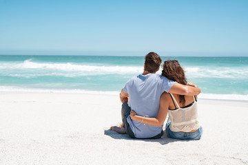 Couple embracing and sitting on beach
