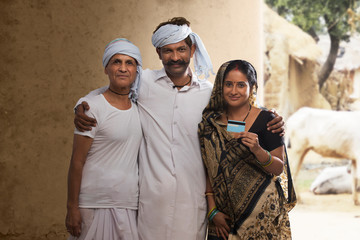 Fototapeta premium Indian rural farmer family holding credit card 