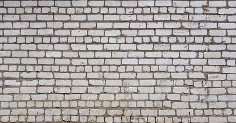 Grey brick wall with traces of destruction and dirty texture
