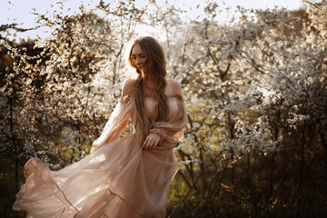 beautiful girl in flowering trees. woman in tulle powdery dress in the garden. fabulous and cute...