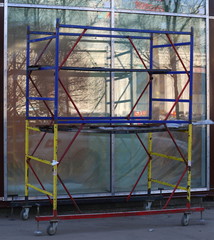 Mobile scaffolding on wheels at an empty glass shop window