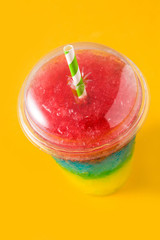 Colorful slushie of differents flavors on yellow background	