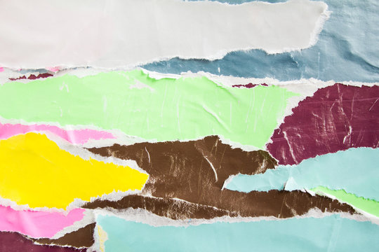 White, green and brown torn, crumpled and shabby pieces of paper placards on wall billboard. Bright colorful ripped and peeling posters with scratches texture background.