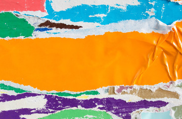 Orange torn and crumpled piece of paper placard on street billboard with old ripped and peeling...
