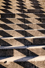 Abstract background shot with a pattern created by harsh shadows on a concrete staircase in the city. Seen in Germany in April.
