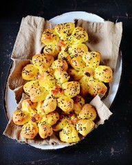 Homemade buns with raisins and sesame seeds on a dark blue wooden background