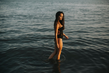 Young woman walking in water at the beach