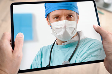 Docteur médecin en téléconsultation avec tablette et main du patient à domicile