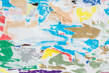  Colorful torn crumpled and peeling pieces of old paper placard and poster layers on billboard...