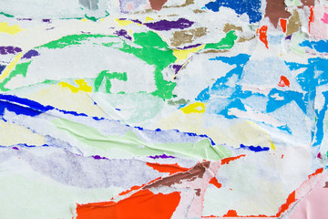 Torn crumpled and peeling pieces of old paper layers on billboard. Abstract urban grunge background.