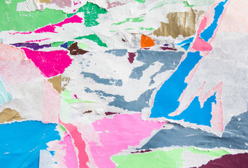 Colorful torn crumpled and peeling pieces of old paper layers texture background.