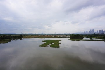 tranquil lake looking like a puzzle with city in the distance