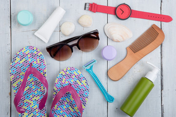 Travel concept - flip flops, swimsuit, sunglasses and sunblock, packaging for beach vacation