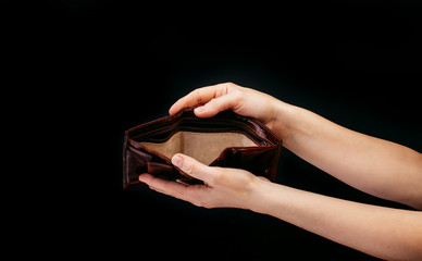 An empty wallet in the hands of a woman, the crisis deprived of income, fear of unemployment