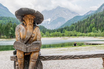 Wooden reading dwarf at lake Jasna in Slovenia