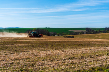 Farmer in tractor sowing wheat field at spring , czech jeseniky 04.16.2020