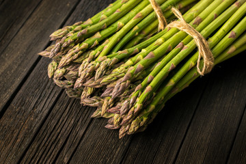 Bunch of fresh green asparagus spears on a rustic wooden table