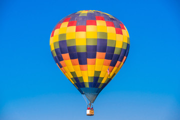 Close up hot air balloon flying up on cosmos field with blue sky background