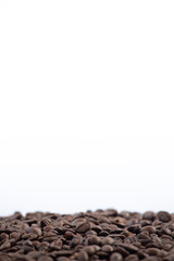 Roasted coffee beans on pile of roasted coffee beans ,isolated in white background