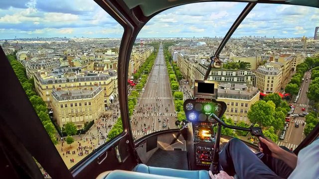 Helicopter cockpit flying on Paris skyline of the French capital, Europe. Scenic flight above Place de l'Etoile and Avenues Champs Elysees street of Paris at sunset.