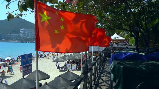 view on the flag of People's Republic of China fluttering on the wind beach island Hainan in The South China Sea summer vacation