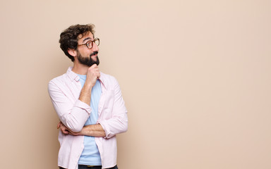 young bearded man expressing a concept against flat wall