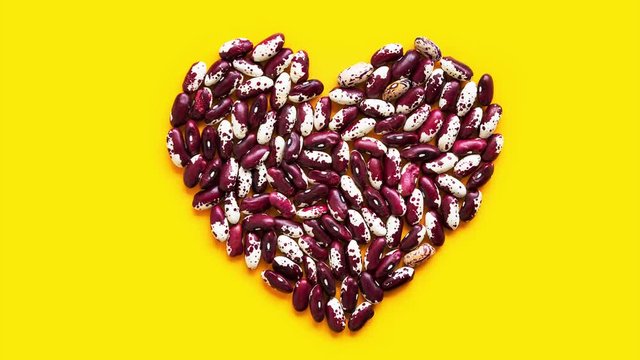Medical footage for heart health concept animated flickering letter F from beans for folic acid on yellow background. Plant based vegan food dietary fiber