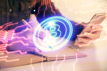 Double exposure of blockchain business sketch hologram and woman holding and using a mobile device.