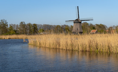 Tradycyjny, holenderski wiatrak nad kanałem wodnym, Alkmaar w Holandii Północnej. © Bozena