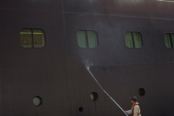 Sailors wash the ship. A large cruise ship is being cleaned at the port. Dry Dock.