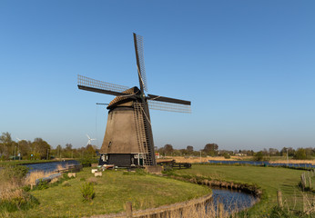Plakat Holenderski wiatrak nad kanałem wodnym, Alkmaar w Holandii Północnej. 