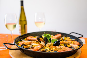 Seafood paella on an orange background