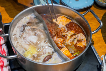 Customized combo pot with boiling hot soups, one spicy flavor and one mushroom flavor.