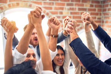 Group of business workers smiling happy. Standing with fists up at the office