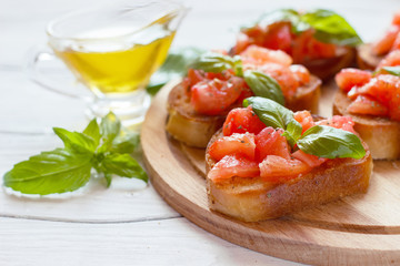 Bruschetta with tomatoes and basil on a wooden board