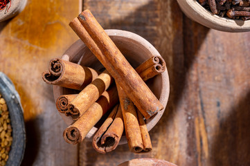 Indian spices collection, dried aromatic cinnamon barks and another spices in clay bowls