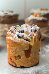 Cruffin as Easter cake decorated with raisins, dried apricots and sugar powder on kitchen table