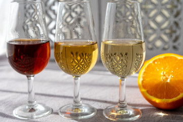 Glasses with cold dry fino and sweet cream sherry fortified wine in sunlights, andalusian style interior on background