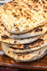 Stack of homemade pita bread, flatbread pile for sale during food festival.