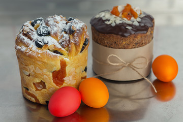 Cruffin and brown Easter cake decorated with chocolate, almond flakes and dried apricots on kitchen table among easter eggs